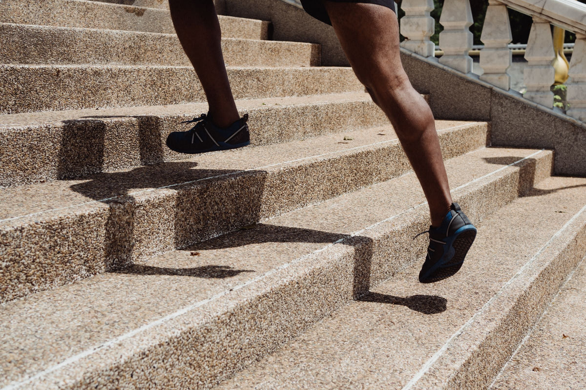 Runner's legs climbing stone steps