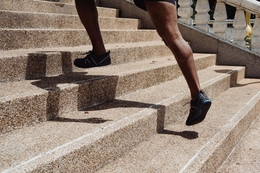 Runner's legs climbing stone steps